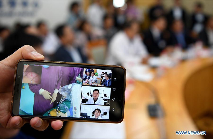 Mobile phone footage in this photo shows experts of the Second Hospital of Anhui Medical University (AMU) guiding an endoscopic surgery conducted by the Shitai County People\'s Hospital through a 5G-supported remote collaborative operating platform at the Second Hospital of AMU in Hefei, east China\'s Anhui Province, May 10, 2019. The first 5G network-supported remote collaborative operation was successfully conducted Friday at two hospitals in Anhui. Medical experts from the Second Hospital of AMU guided two endoscopic surgeries operated by another county hospital via 5G technology remotely and timely, during which the experts remote-adjusted the operating machines through voice. (Xinhua/Liu Junxi)
