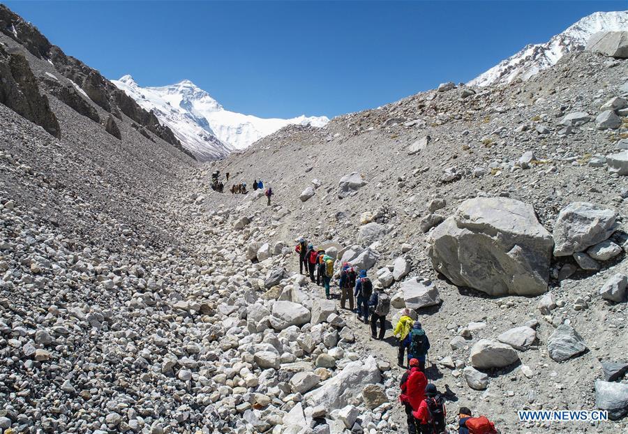 Climbers carry out adapting training on the northern face of Mount Qomolangma in southwest China\'s Tibet Autonomous Region, April 25, 2019. Every year, for a few weeks, hundreds of climbers and supporting personnel come to the base camp of the northern face of Mount Qomolangma, trying to reach the summit of the tallest and most famous mountain in the world. Before starting climbing, they need to hike several times between elevations from 5,000 meters to 7,000 meters, giving their bodies some time to adapt. When this process is over, it\'s all up to the weather. The base camp is a popular place to wait for the window. Among the six camps on the northern face, the base camp at an altitude of 5,200 meters is the furthest cars can reach and therefor the most equipped. Besides food and accommodation, climbers can also enjoy tea and massage. They can also play football on perhaps the highest field. There\'s even a simple gym in the camp. Environmental protection is a priority here. Garbage sacks are given to each climbing team. Special containers are put in every camp to collect trash and sewage. The collected trash must be treated 100 kilometers away, and the only road is a zigzagging track. It is not trucks, but yaks that are generally used to make the journey. Actually yaks are vital on the mountain. Beyond the base camp, yak is the only reliable transport. (Xinhua/Sun Fei)