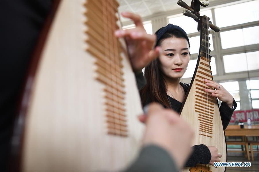 Player Zhao Xiaotong practices playing the pipa at Lanzhou traditional orchestra in Lanzhou, northwest China\'s Gansu Province, May 13, 2019. Pipa, a pear-shaped stringed instrument, is one of the traditional Chinese musical instruments. The pipa is played vertically and can be found in solos, ensembles or orchestras. The images of flying apsaras playing the pipa have been seen on murals in Gansu\'s Dunhuang Mogao Grottoes, a 1,600-year-old UNESCO world heritage site located at a cultural and religious crossroads area on the ancient Silk Road in Gansu. Nowadays contemporary dance performances inspired from those images on the murals have been staged times and times again. (Xinhua/Chen Bin)
