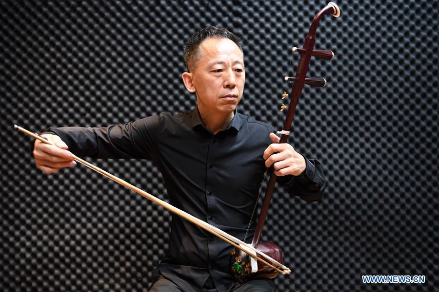 Erhu performer Zhang Zhijun plays Erhu in Lanzhou, northwest China\'s Gansu Province, May 13, 2019. Erhu, sometimes known as the Chinese violin or Chinese two-stringed fiddle, is a Chinese traditional two-stringed bowed musical instrument. It is used as a solo instrument as well as in small ensembles and large orchestras. Erhu, traced back to ancient Chinese Tang dynasty (618-907), is now used in both traditional and contemporary music arrangements, such as in pop, rock and jazz. The famous solo pieces include Er Quan Ying Yue (Two Springs Reflecting the Moon) by Abing and Sai Ma (Horse Race) by Huang Haihuai. (Xinhua/Fan Peishen)