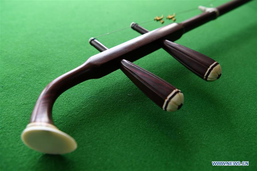 Photo taken on May 13, 2019 shows the tuning pegs and neck of an Erhu in Lanzhou, northwest China\'s Gansu Province. Erhu, sometimes known as the Chinese violin or Chinese two-stringed fiddle, is a Chinese traditional two-stringed bowed musical instrument. It is used as a solo instrument as well as in small ensembles and large orchestras. Erhu, traced back to ancient Chinese Tang dynasty (618-907), is now used in both traditional and contemporary music arrangements, such as in pop, rock and jazz. The famous solo pieces include Er Quan Ying Yue (Two Springs Reflecting the Moon) by Abing and Sai Ma (Horse Race) by Huang Haihuai. (Xinhua/Fan Peishen)