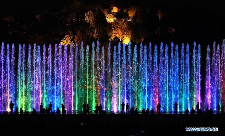 Tourists enjoy a light show at the Olympic Forest Park in Beijing, capital of China, May 14, 2019. Roads and buildings were illuminated Tuesday evening before the upcoming Conference on Dialogue of Asian Civilizations (CDAC) in Beijing. (Xinhua/Ju Huanzong)