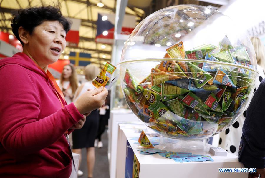 A visitor views exhibits in front of the booth of a Ukrainian juice exhibitor during the 20th SIAL China in Shanghai, east China, May 14, 2019. The 20th SIAL China, an international food and beverage exhibition, kicked off at Shanghai New International Expo Center on Tuesday. The exhibition has attracted nearly 4,300 exhibitors from different countries and regions . (Xinhua/Fang Zhe)
