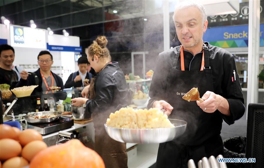 A German chef cooks during the 20th SIAL China in Shanghai, east China, May 14, 2019. The 20th SIAL China, an international food and beverage exhibition, kicked off at Shanghai New International Expo Center on Tuesday. The exhibition has attracted nearly 4,300 exhibitors from different countries and regions . (Xinhua/Fang Zhe)