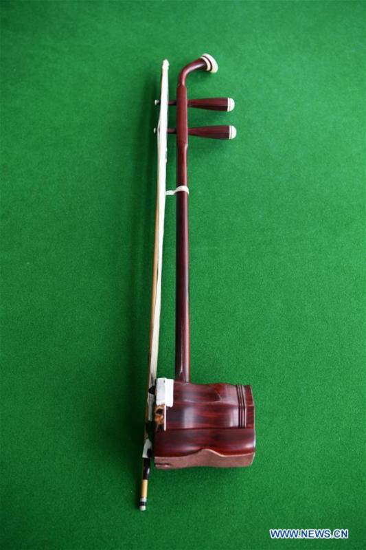 An Erhu is pictured in Lanzhou, northwest China\'s Gansu Province, May 13, 2019. Erhu, sometimes known as the Chinese violin or Chinese two-stringed fiddle, is a Chinese traditional two-stringed bowed musical instrument. It is used as a solo instrument as well as in small ensembles and large orchestras. Erhu, traced back to ancient Chinese Tang dynasty (618-907), is now used in both traditional and contemporary music arrangements, such as in pop, rock and jazz. The famous solo pieces include Er Quan Ying Yue (Two Springs Reflecting the Moon) by Abing and Sai Ma (Horse Race) by Huang Haihuai. (Xinhua/Fan Peishen)