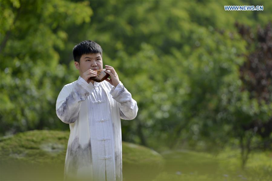 Li Xin plays the Ocarina, a flute-like instrument, in the fields in Xingtai, north China\'s Hebei Province, May 14, 2019. Ocarina is a wind musical instrument typically having an enclosed oval body with finger holes and a projecting mouthpiece. It is traditionally made of clay or ceramic, but other materials including wood and horn are used. It is an ancient instrument and can be traced back to many different cultures. (Xinhua/Mu Yu)