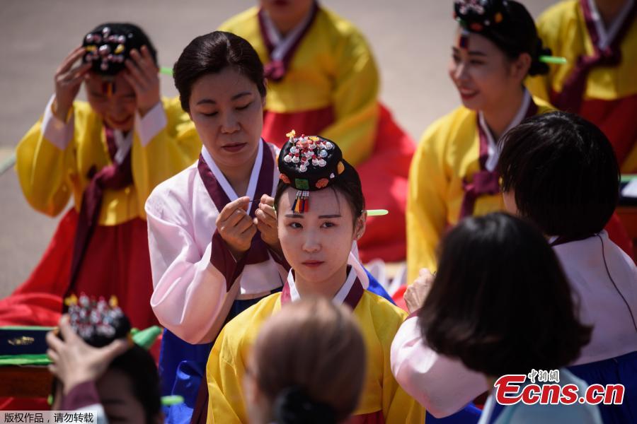 A participant recieves a traditional Korean flower cap during a traditional Coming-of-Age Day ceremony to mark adulthood at Namsan hanok village in Seoul on May 20, 2019.  The ceremony marks the age of 19, at which a person is legally able to make life choices from voting, to drinking alcohol.(Photo/Agencies)