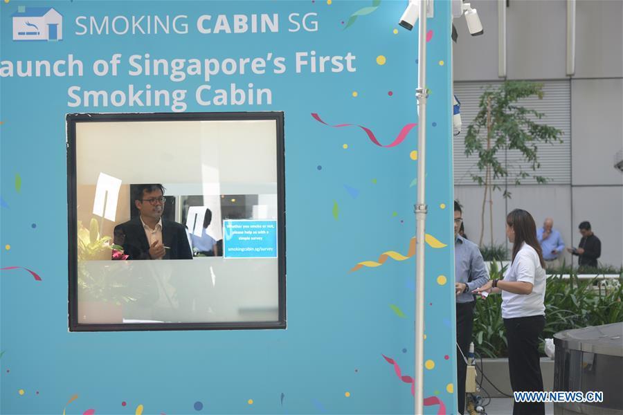 A man smokes inside a smoking cabin in Singapore on May 21, 2019. Singapore\'s first smoking cabin was launched on Tuesday. The air-conditioned cabin measures 4.8 square metres in size, that allows a maximum of 10 users at one time, and uses 3 filters to filter the air inside. (Xinhua/Then Chih Wey)
