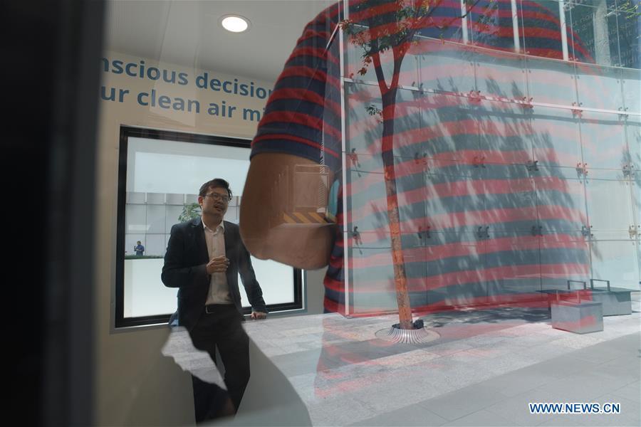 People smoke inside a smoking cabin in Singapore on May 21, 2019. Singapore\'s first smoking cabin was launched on Tuesday. The air-conditioned cabin measures 4.8 square metres in size, that allows a maximum of 10 users at one time, and uses 3 filters to filter the air inside. (Xinhua/Then Chih Wey)