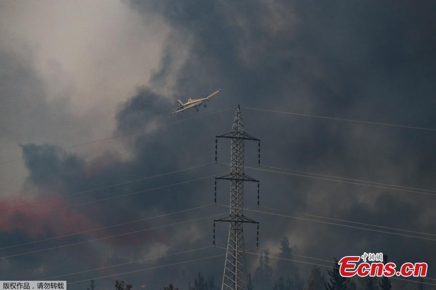 A picture taken on May 23, 2019 shows a helicopter flying over a burning forest amidst extreme heat wave near the Israeli city of Modiin on May 23, 2019. (Photo/Agencies)