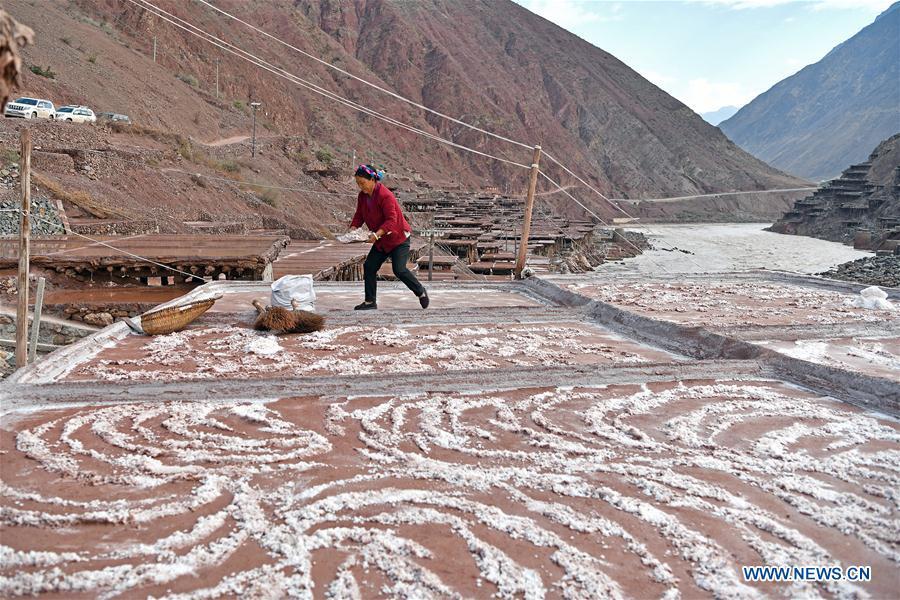 A villager collects salt at a saline field in Mangkam County, southwest China\'s Tibet Autonomous Region, May 22, 2019. An ancient technique of salt production since Tang Dynasty (618-907) is well-preserved in Mangkam County. Local people follow a salt harvesting method by collecting brines from salt mines and ponds and evaporating them in the sun until crystallization. (Xinhua/Li Xin)
