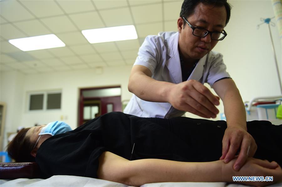 A doctor gives acupuncture treatment to a patient at Cangzhou People\'s Hospital in Cangzhou, north China\'s Hebei Province, May 26, 2019. Traditional medicine originating from Traditional Chinese Medicine (TCM) has been incorporated into the 11th revision of the International Classification of Diseases (ICD), marking a major step for TCM\'s internationalization. The revision was approved Saturday at the 72 World Health Assembly being held in Geneva, Switzerland, according to China\'s National Administration of Traditional Chinese Medicine. (Xinhua/Fu Xinchun)