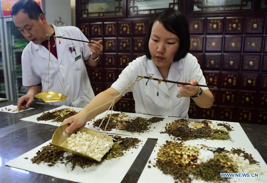 Staff members of Cangzhou People\'s Hospital fill prescriptions of Traditional Chinese Medicine for patients in Cangzhou, north China\'s Hebei Province, May 26, 2019. Traditional medicine originating from Traditional Chinese Medicine (TCM) has been incorporated into the 11th revision of the International Classification of Diseases (ICD), marking a major step for TCM\'s internationalization. The revision was approved Saturday at the 72 World Health Assembly being held in Geneva, Switzerland, according to China\'s National Administration of Traditional Chinese Medicine. (Xinhua/Fu Xinchun)