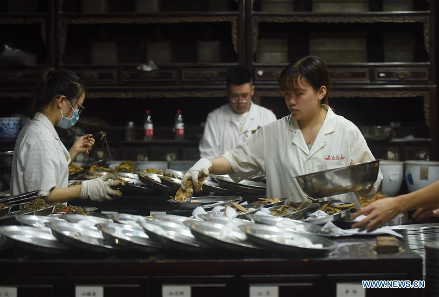 Staff members of a pharmacy fill prescriptions of Traditional Chinese Medicine for patients in Hangzhou, east China\'s Zhejiang Province, May 26, 2019. Traditional medicine originating from Traditional Chinese Medicine (TCM) has been incorporated into the 11th revision of the International Classification of Diseases (ICD), marking a major step for TCM\'s internationalization. The revision was approved Saturday at the 72 World Health Assembly being held in Geneva, Switzerland, according to China\'s National Administration of Traditional Chinese Medicine. (Xinhua/Long Wei)