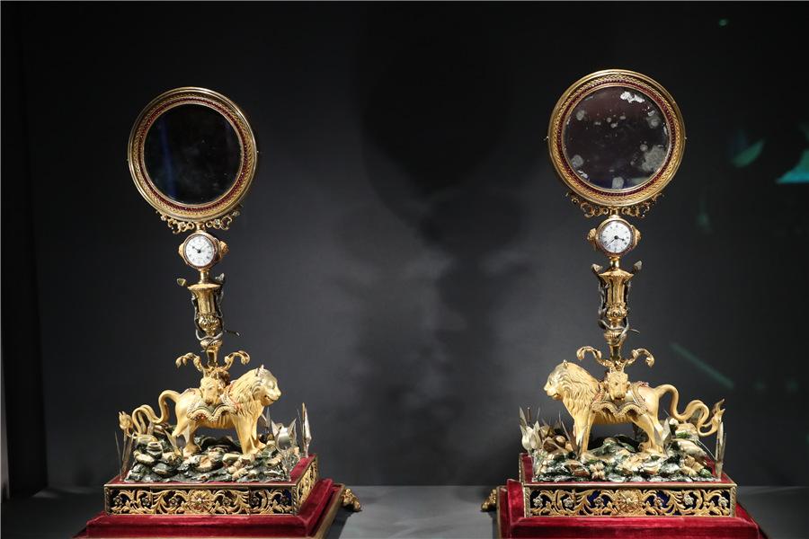 A pair of clocks with mirrors and lion-shape decorations are among six timepieces benefiting from the cooperation between the Palace Museum and Cartier. (Photo provided to China Daily)

The Symbols of Power section of the exhibition displays tiaras, bracelets, necklaces and other items of jewelry owned by royal courts and celebrities from all over Europe, Asia and North America, which combine to present a sparkling fiesta for the eyes. An emphasis was particularly placed on presenting the rise of the modernist style of the early 20th century, marking the birth of the Art Deco movement and plotting the evolution of fashion.

\