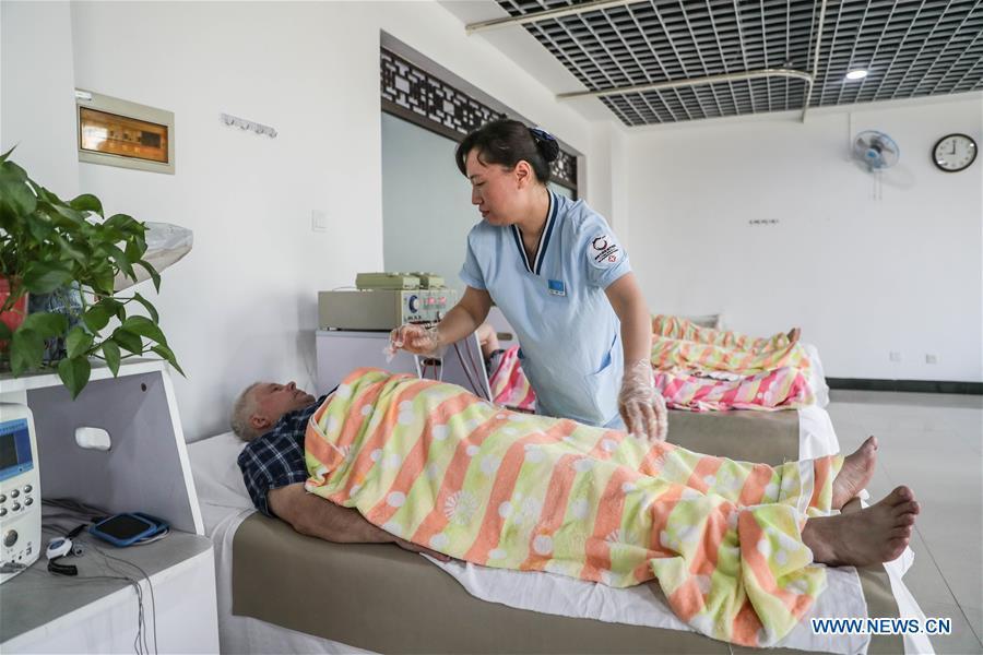 A Russian patient receives physiotherapy at Tanggangzi Hospital in Anshan, northeast China\'s Liaoning Province, June 4, 2019. Featured with traditional Chinese medicine therapy, Tanggangzi Hospital has attracted many Russian patients who come here to receive rehabilitation treatments, such as acupuncture, physiotherapy, cephalic magnet therapy. The hospital received more than 6,000 Russian patients in one year at the peak. (Xinhua/Pan Yulong)