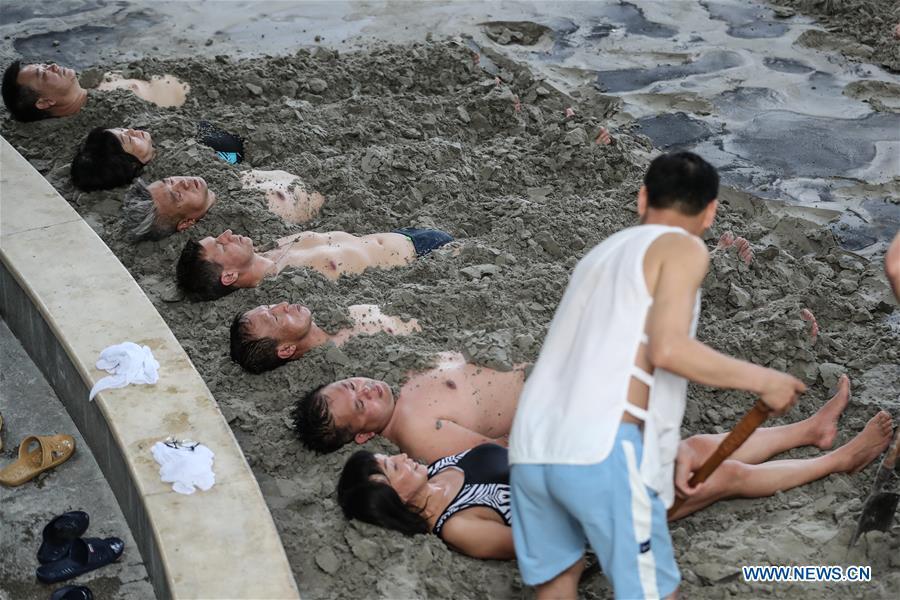 A Russian patient (4th L) receives physiotherapy through thermal mineral mud-bath at Tanggangzi Hospital in Anshan, northeast China\'s Liaoning Province, June 4, 2019. Featured with traditional Chinese medicine therapy, Tanggangzi Hospital has attracted many Russian patients who come here to receive rehabilitation treatments, such as acupuncture, physiotherapy, cephalic magnet therapy. The hospital received more than 6,000 Russian patients in one year at the peak. (Xinhua/Pan Yulong)