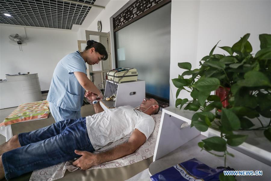 A Russian patient receives physiotherapy at Tanggangzi Hospital in Anshan, northeast China\'s Liaoning Province, June 4, 2019. Featured with traditional Chinese medicine therapy, Tanggangzi Hospital has attracted many Russian patients who come here to receive rehabilitation treatments, such as acupuncture, physiotherapy, cephalic magnet therapy. The hospital received more than 6,000 Russian patients in one year at the peak. (Xinhua/Pan Yulong)