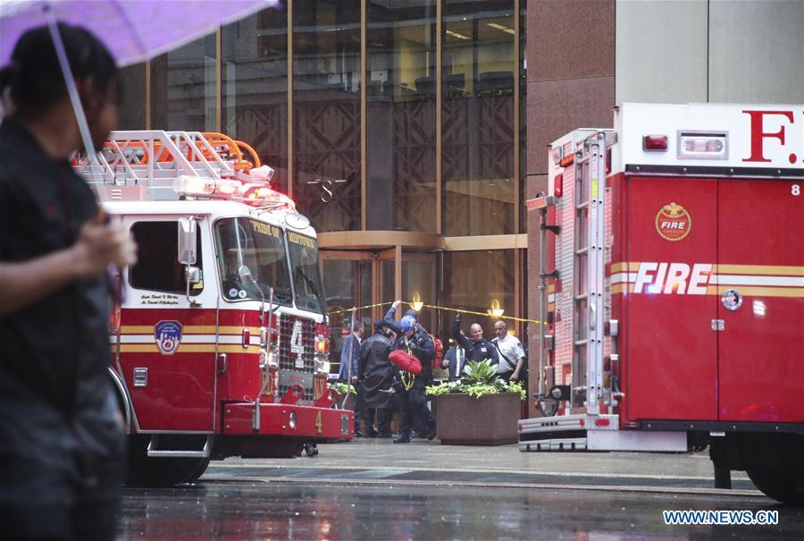 Rescuers and police officers walk out of the building where a helicopter crashed in Manhattan, New York, the United States, June 10, 2019. One person was killed after a helicopter crashed onto the roof of a skyscraper in Midtown Manhattan of New York City Monday afternoon, according to media reports. (Xinhua/Wang Ying)