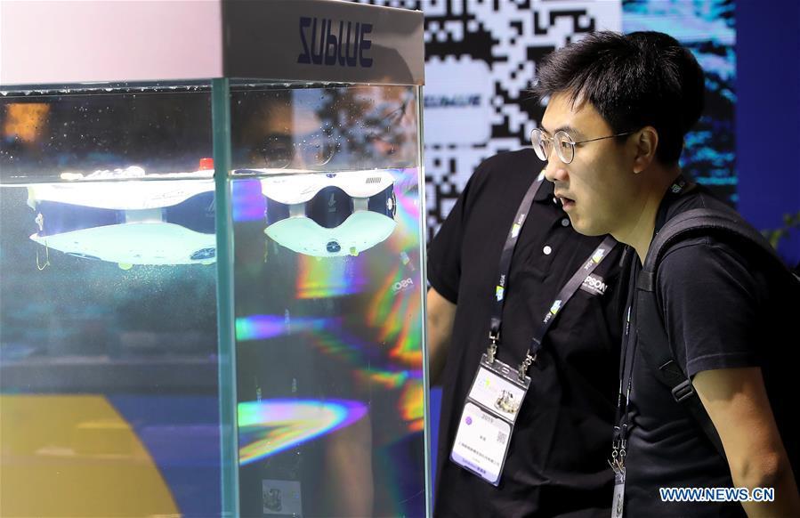 Visitors view underwater photographic robots during the 2019 Consumer Electronics Show (CES) Asia in east China\'s Shanghai, June 11, 2019. The 2019 Consumer Electronics Show (CES) Asia kicked off on Tuesday in Shanghai. The three-day exhibition showcased the latest achievements in 5G technology, artificial intelligence, augmented/virtual reality and vehicle technology. (Xinhua/Fang Zhe)