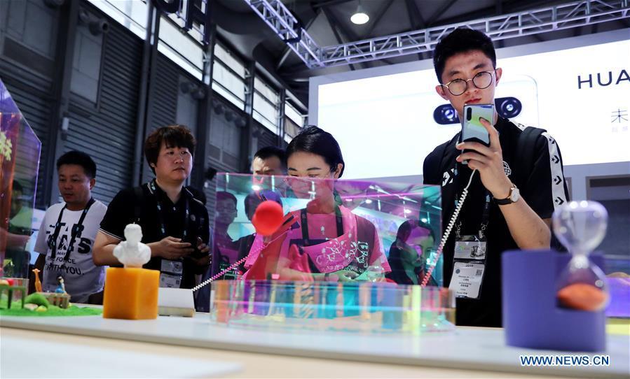 Visitors try mobile phones during the 2019 Consumer Electronics Show (CES) Asia in east China\'s Shanghai, June 11, 2019. The 2019 Consumer Electronics Show (CES) Asia kicked off on Tuesday in Shanghai. The three-day exhibition showcased the latest achievements in 5G technology, artificial intelligence, augmented/virtual reality and vehicle technology. (Xinhua/Fang Zhe)