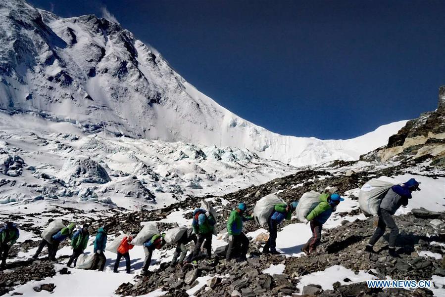 People carry garbage on Mount Qomolangma in southwest China\'s Tibet Autonomous Region in May 2018. (Xinhua)