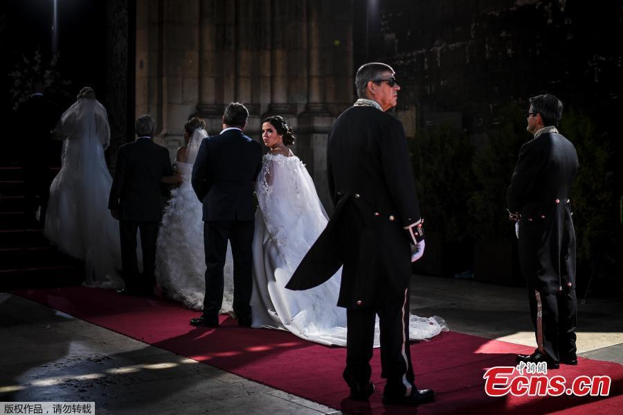 Brides and their best-men queue to enter the cathedral ahead of the celebration of a multiple wedding ceremony in Lisbon on June 12, 2019. It is Lisbon\'s wedding of the year. Crowds gather at the cathedral, hoping to catch a glimpse of the newlyweds as cameras lie in wait. Then not one, but 11 couples walk out, fresh from tying the knot today in an all-expenses-paid ceremony, the beneficiaries of a decades-long annual tradition that fetes the Portuguese capital\'s beloved patron Saint Anthony, matchmaker extraordinaire.(Photo/Agencies)