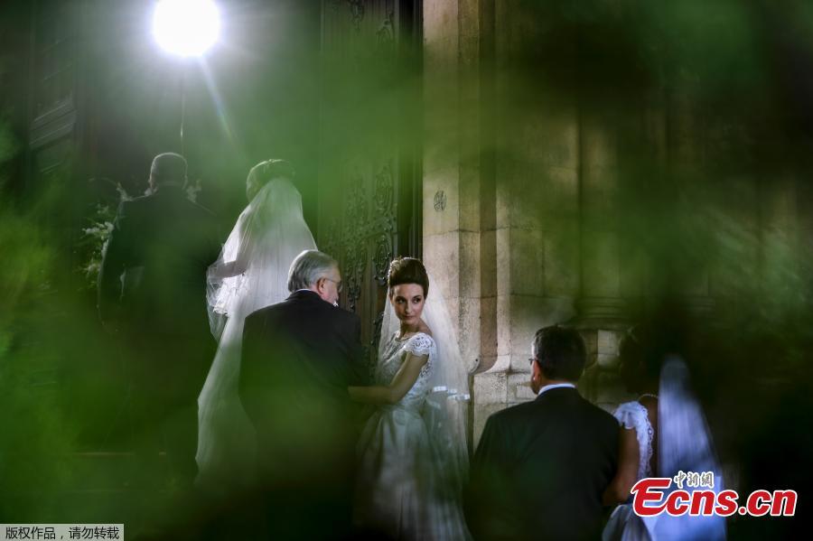 Brides and their best-men queue to enter the cathedral ahead of the celebration of a multiple wedding ceremony in Lisbon on June 12, 2019. It is Lisbon\'s wedding of the year. Crowds gather at the cathedral, hoping to catch a glimpse of the newlyweds as cameras lie in wait. Then not one, but 11 couples walk out, fresh from tying the knot today in an all-expenses-paid ceremony, the beneficiaries of a decades-long annual tradition that fetes the Portuguese capital\'s beloved patron Saint Anthony, matchmaker extraordinaire. (Photo/Agencies)