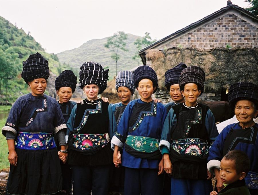 Dorothy Lacy, third from left, and some of the craftswomen who create embroidered items for the Shenaini website pose in Miao traditional costume in 2006. (Photo provided to chinadaily.com.cn)

The Lacys have lived in Fenghuang for more than 13 years since Paul sold his property in the States in 2006 and purchased a residence on the bank of the Tuojiang River.

Before they settled in Fenghuang, the couple\'s footsteps were left in vast swaths of China. For example, they traveled to cities, such as Beijing and Xi\'an, and provinces like South China\'s Guizhou and Northwest China\'s Xinjiang Uygur autonomous region.

\