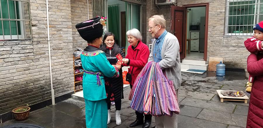 Paul and Dorothy Lacy give a gift in a red envelope to a Miao woman who is one of their \