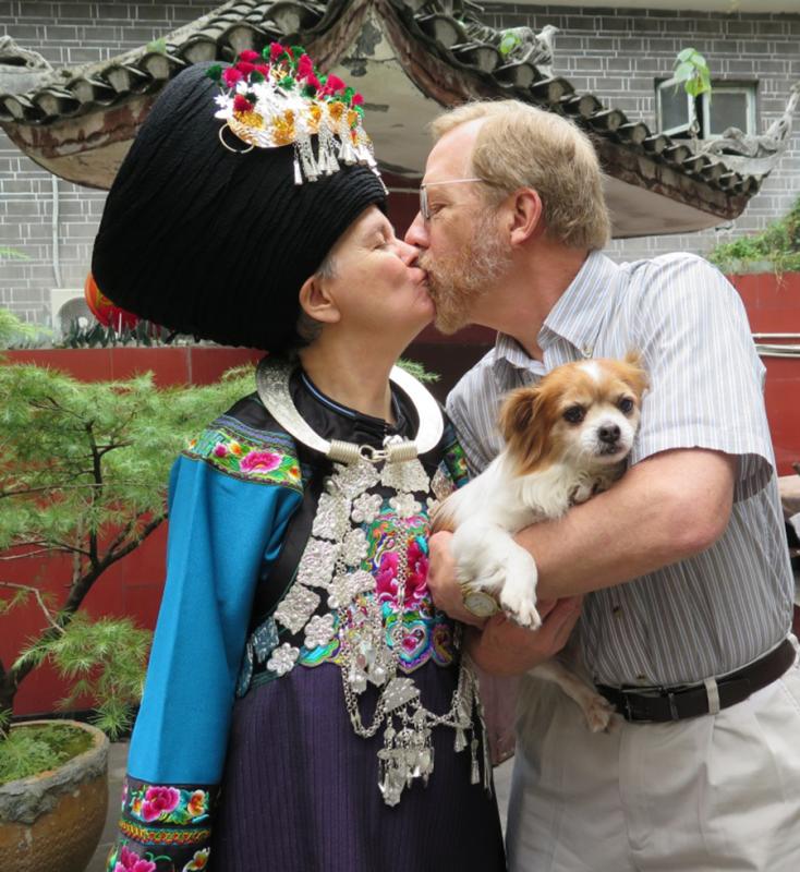 Paul Lacy and his wife, Dorothy, who is dressed in traditional Miao costume, share a kiss. (Photo provided to chinadaily.com.cn)