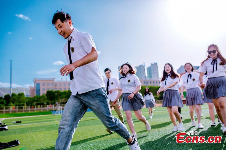 Graduates at Qinghai Nationalities University in Xining City, Qinghai Province relax into their own poses for graduation photos. The university held its graduation ceremony on Monday. (Photo provided to China News Service)