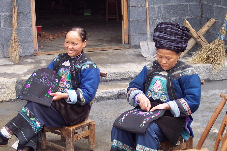 Miao women embroider flowers onto bags.  (Photo provided to chinadaily.com.cn)

Now the Lacy\'s company has 30 employees, with seven working full-time and 15 or 16 women who work part-time at home. Most of the Miao women who embroider for the company have children, and they can travel to the company once a week to take embroidery materials back home so that they can work while taking care of their families, they said. 

The Lacys said that their products have been selling well in the US market because Americans love ethnic handicrafts. They noted that the subprime mortgage crisis in 2008 took a heavy toll on sales. At that time, their customers were largely from South China\'s Guangdong province and Hong Kong.