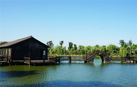 Hongshancun, about a 20-minute drive from Wuzhen, hosts lush trees, wooden bridges, lakes and historical buildings. (Photo provided to China Daily) Hongshancun, about a 20-minute drive from Wuzhen, hosts lush trees, wooden bridges, lakes and historical buildings. (Photo provided to China Daily)