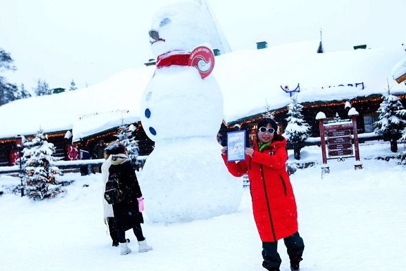 A Chinese tourist takes a photo with a snowman at a scenic spot in Finland.(Photo by Xu Kangping/for China Daily) A Chinese tourist takes a photo with a snowman at a scenic spot in Finland.(Photo by Xu Kangping/for China Daily)