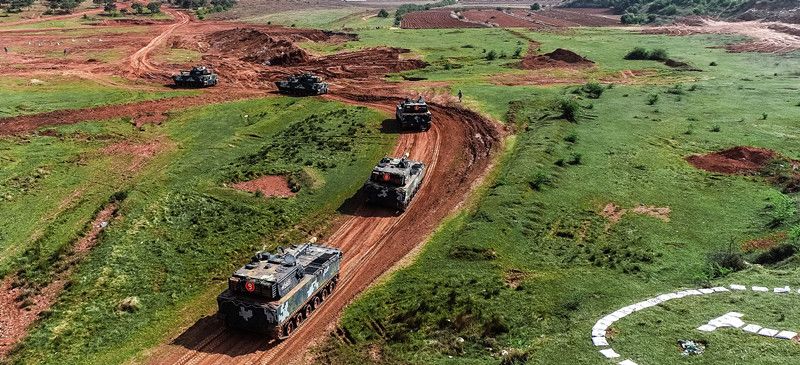 Amphibious armored vehicles rumble in plateau area