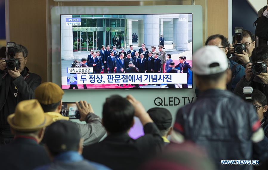 People watch news from screen on meeting of South Korean, DPRK leaders