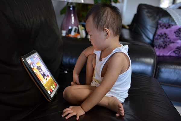 An 1-year-old baby plays a game on an iPad. (Jiang Xiaoying/For China Daily) An 1-year-old baby plays a game on an iPad. (Jiang Xiaoying/For China Daily)
