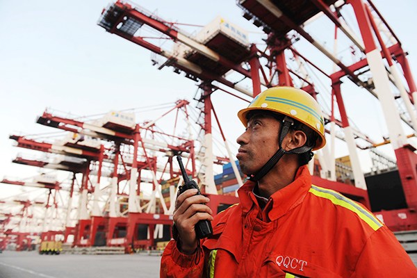 A worker looks closely as containers are unloaded in Qingdao Port, Shandong province. (Photo/China Daily) A worker looks closely as containers are unloaded in Qingdao Port, Shandong province. (Photo/China Daily)