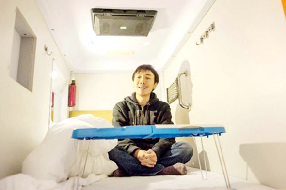 A guest erected a collapsible desk in a capsule hotel in Chongqing in 2012. (Photo/Xinhua) A guest erected a collapsible desk in a capsule hotel in Chongqing in 2012. (Photo/Xinhua)